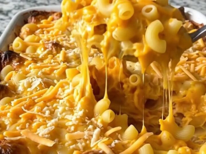 A top-down view of a creamy butternut squash mac and cheese bake in a ceramic dish, covered in golden melted sharp cheddar.