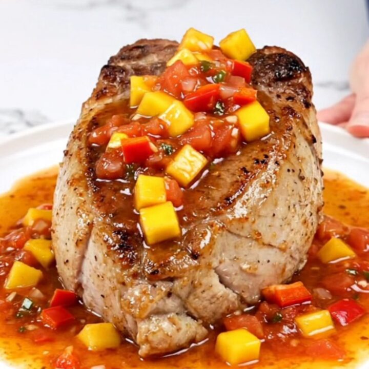 Slow cooker pork tenderloin topped with a vibrant mixture of diced mango, red pepper, and salsa.