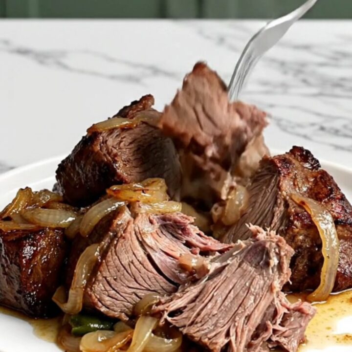 A rustic slow cooker pot roast featuring tender beef chuck, halved baby potatoes, and vibrant green beans in savory juices.