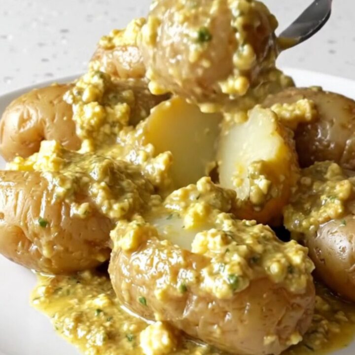 A close-up view of creamy garlic herb potatoes in a slow cooker, looking rich and appetizing.