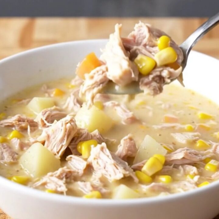 A bowl of creamy Crockpot Cheesy Turkey Corn Chowder with visible turkey crumbles and corn kernels.