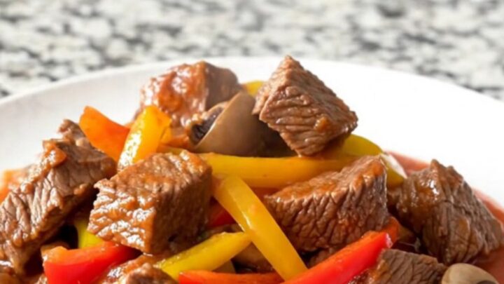 A hearty bowl of slow cooker beef tips cacciatore with peppers and mushrooms in a rich tomato sauce.