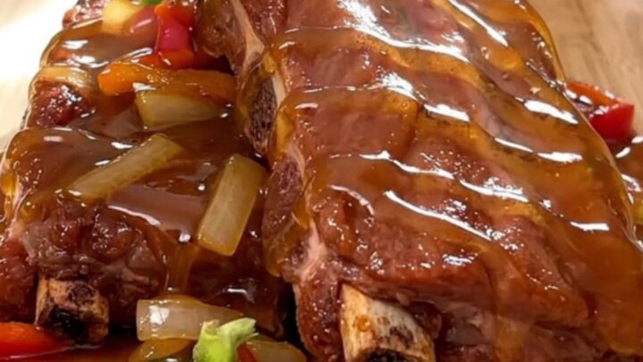 A close-up view of tender, slow-cooked boneless country-style ribs glazed in a rich, shiny Cajun honey sauce.