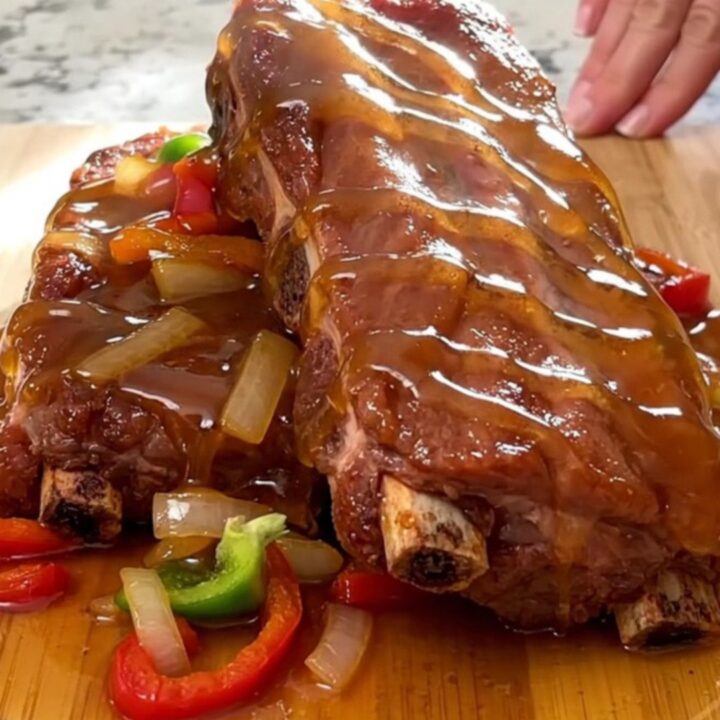 A close-up view of tender, slow-cooked boneless country-style ribs glazed in a rich, shiny Cajun honey sauce.