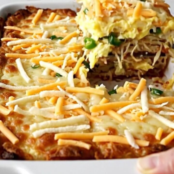 A top-down view of a rectangular ceramic baking dish filled with a golden, baked hash brown and egg casserole.