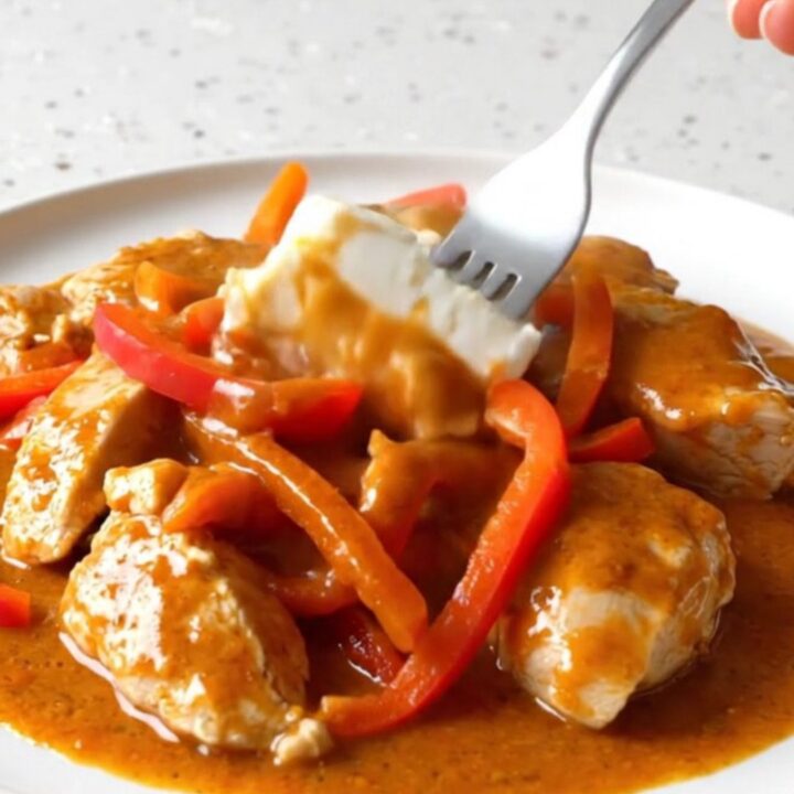 Creamy gochujang chicken breasts with red bell peppers in a rich orange-red sauce.