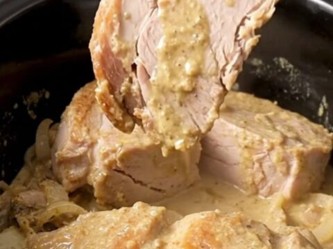 A close-up of tender, creamy Crockpot Swedish Pork Chops served with mushroom gravy.
