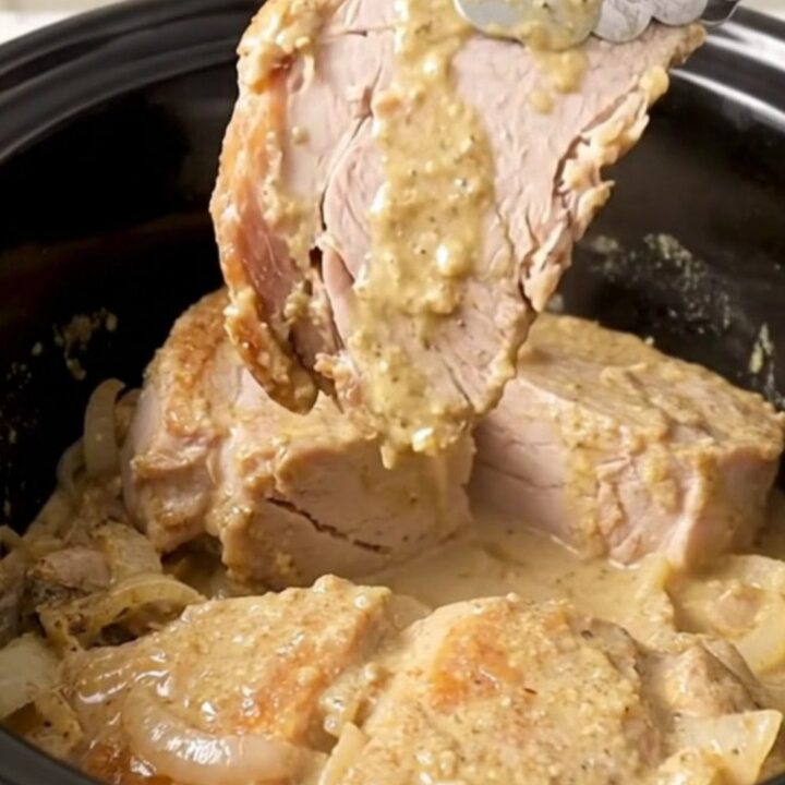 A close-up of tender, creamy Crockpot Swedish Pork Chops served with mushroom gravy.