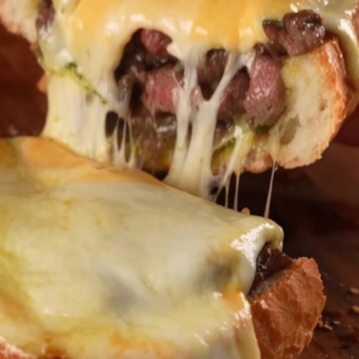A crispy golden-brown French bread loaf stuffed with Philly cheesesteak filling and melted cheese.