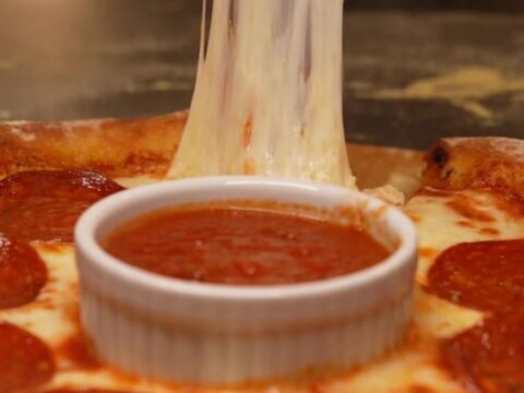A viral stuffed crust pizza ring with a molten cheese border and a warm marinara dipping center.