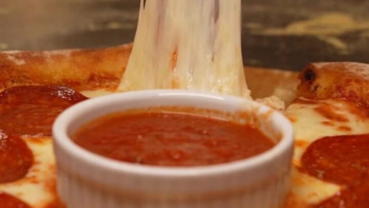 A viral stuffed crust pizza ring with a molten cheese border and a warm marinara dipping center.