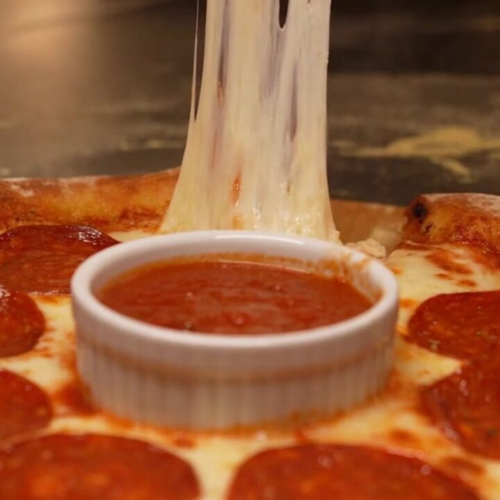 A viral stuffed crust pizza ring with a molten cheese border and a warm marinara dipping center.