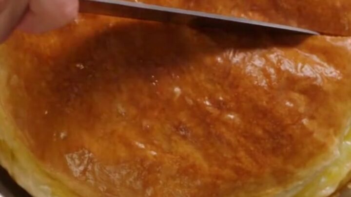 A golden-brown, freshly baked Turkish water borek cut into generous squares on a round tray.