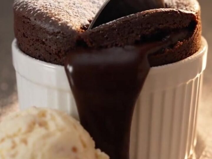 A warm molten chocolate lava mug cake in a ceramic mug with a liquid center.