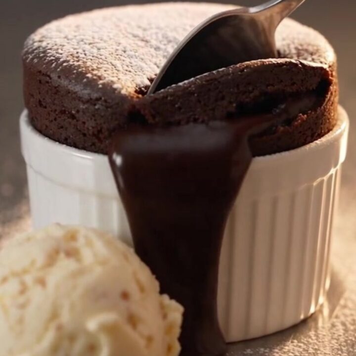 A warm molten chocolate lava mug cake in a ceramic mug with a liquid center.