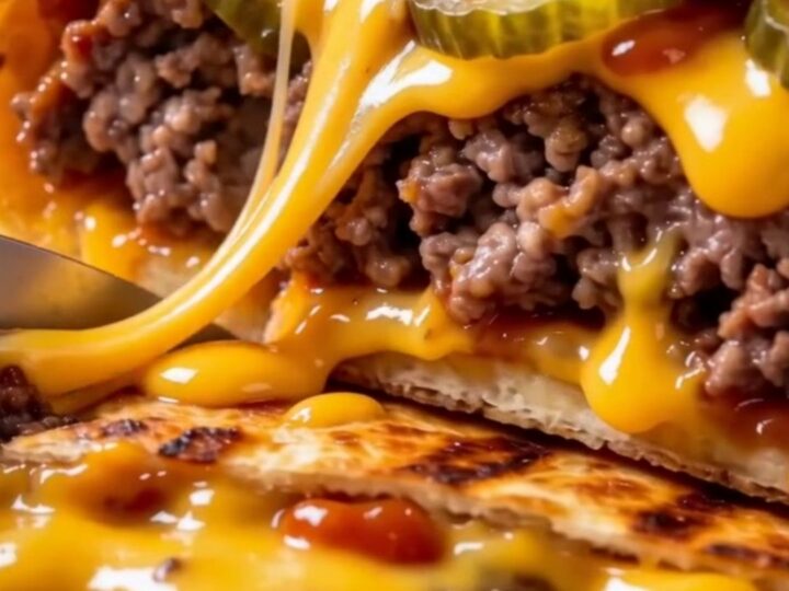 A crispy, golden-brown smash cheeseburger wrap sliced in half on a wooden board, showing layers of beef and melted cheese.
