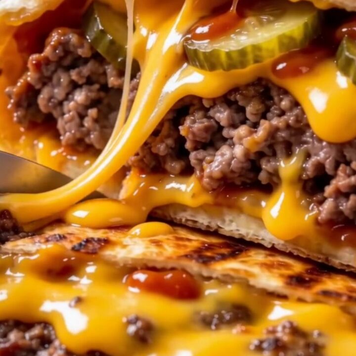 A crispy, golden-brown smash cheeseburger wrap sliced in half on a wooden board, showing layers of beef and melted cheese.