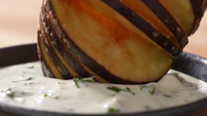 Golden brown fan-cut accordion eggplant fries arranged on a rustic platter.