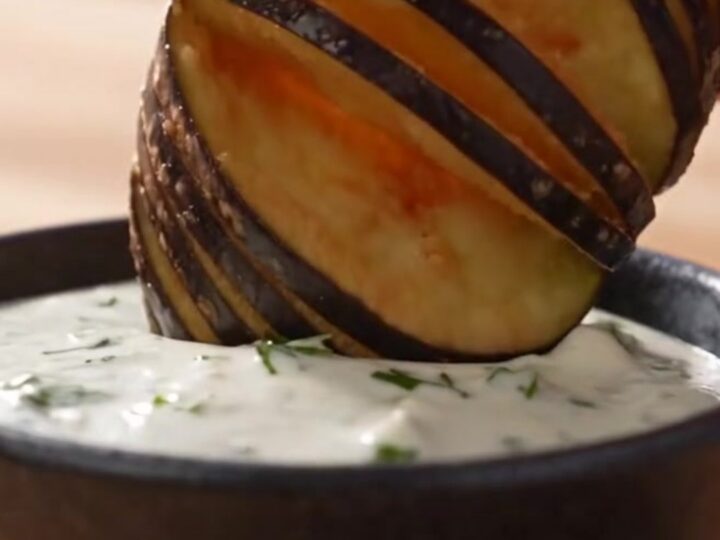 Golden brown fan-cut accordion eggplant fries arranged on a rustic platter.