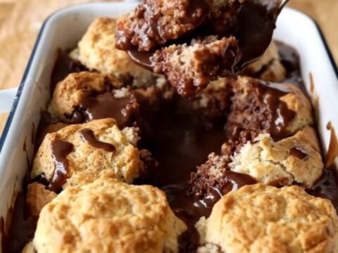 A warm Southern Chocolate Gravy Biscuit Bake in a white enameled baker on a wooden countertop.