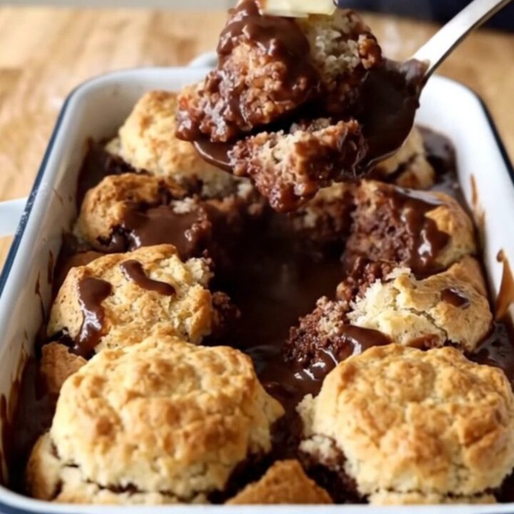 A warm Southern Chocolate Gravy Biscuit Bake in a white enameled baker on a wooden countertop.
