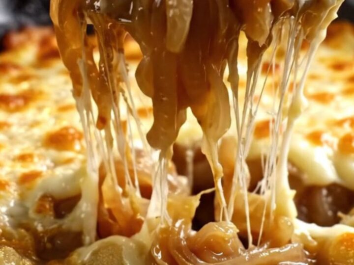 A cast-iron skillet filled with gnocchi in a rich onion broth, covered with a bubbly, golden-brown Gruyère cheese crust.