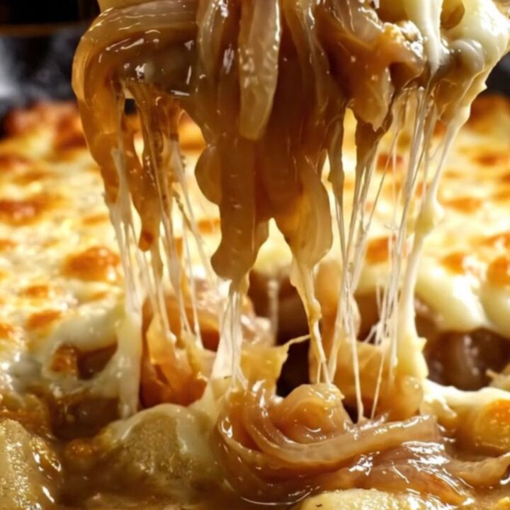 A cast-iron skillet filled with gnocchi in a rich onion broth, covered with a bubbly, golden-brown Gruyère cheese crust.