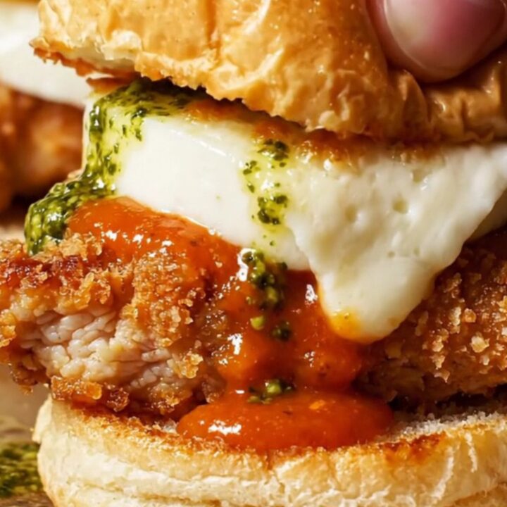 Close-up of crispy chicken parm sliders with vodka sauce and melted mozzarella on brioche buns.