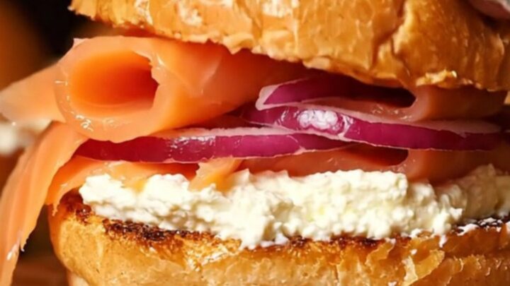 A close-up of everything bagel smoked salmon sliders on a wooden board.