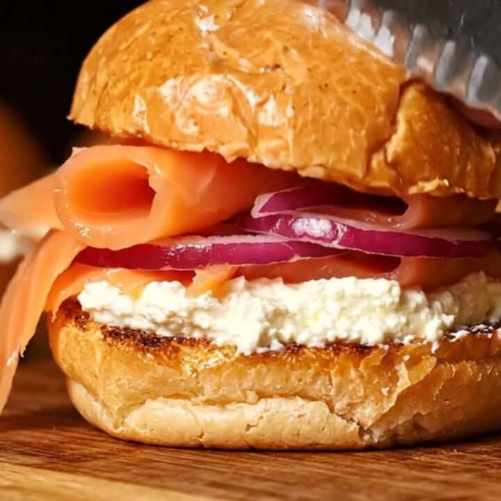 A close-up of everything bagel smoked salmon sliders on a wooden board.