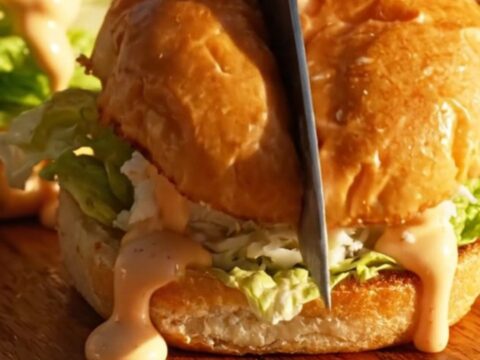 A golden jumbo lump crab cake slider on a toasted brioche bun with remoulade.
