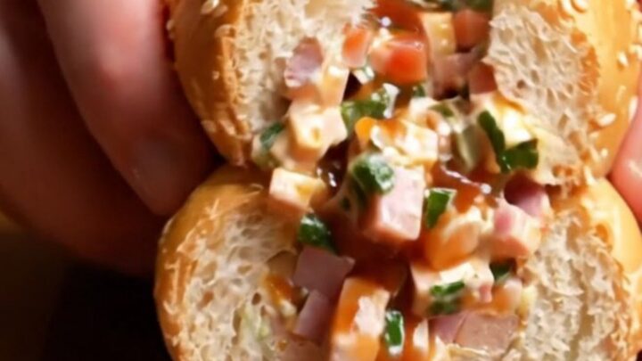 A close-up shot of a chopped Italian sub sandwich on a wooden board