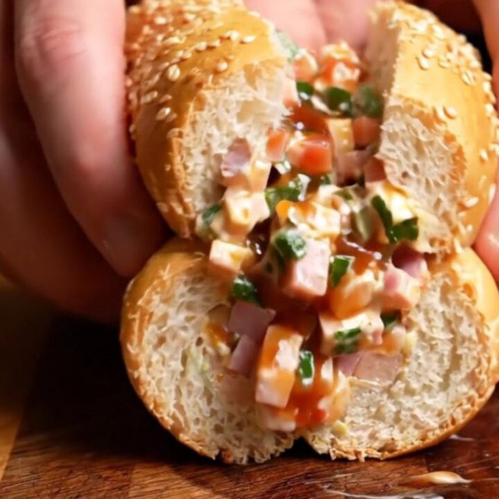 A close-up shot of a chopped Italian sub sandwich on a wooden board