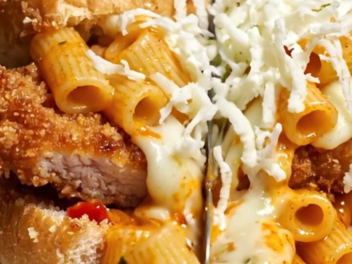 A close-up shot of a crispy chicken parm and vodka rigatoni hero sub cut in half.