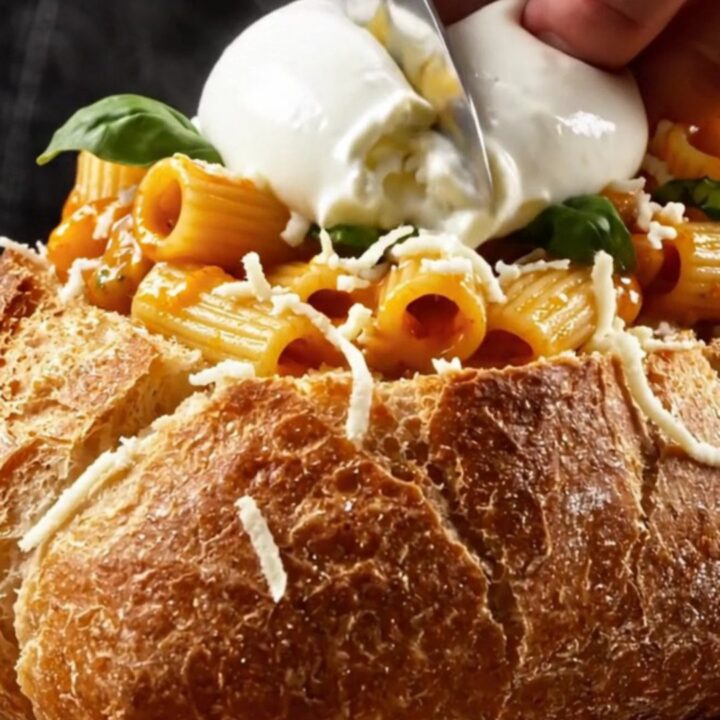 A crispy, golden garlic bread loaf filled with spicy vodka rigatoni and topped with fresh burrata.