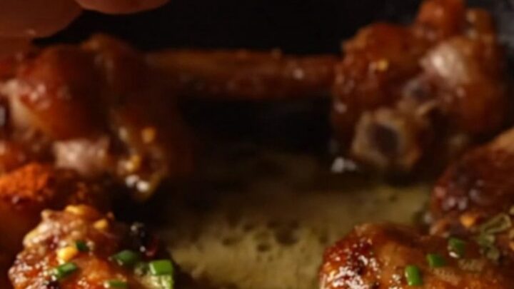 Crispy Cajun blackened wings piled high and glistening with a rich, yellow lemon-Dijon cowboy butter sauce.