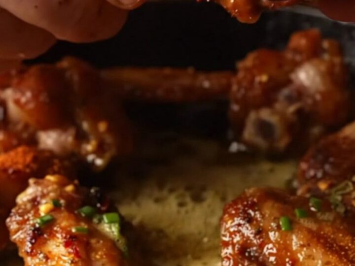 Crispy Cajun blackened wings piled high and glistening with a rich, yellow lemon-Dijon cowboy butter sauce.