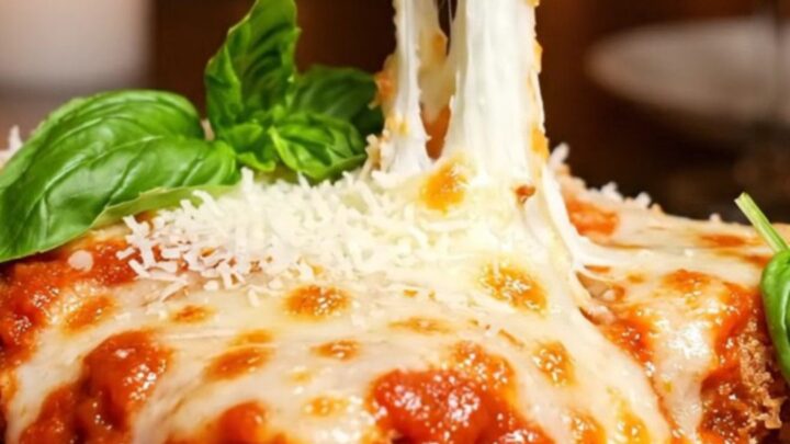 A crispy, golden-fried chicken parmigiana bombe topped with bubbly melted cheese and fresh basil.