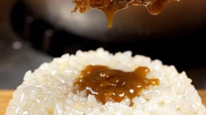 A golden-brown, crispy chicken katsu cutlet served with steaming rice and rich curry sauce.