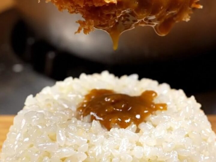 A golden-brown, crispy chicken katsu cutlet served with steaming rice and rich curry sauce.