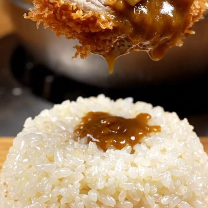 A golden-brown, crispy chicken katsu cutlet served with steaming rice and rich curry sauce.