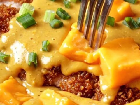 A golden, crispy pretzel-crusted chicken cutlet drizzled with a rich, molten sharp cheddar beer cheese sauce.