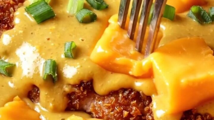 A golden, crispy pretzel-crusted chicken cutlet drizzled with a rich, molten sharp cheddar beer cheese sauce.