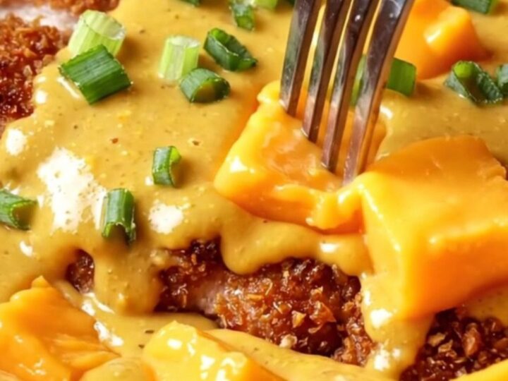A golden, crispy pretzel-crusted chicken cutlet drizzled with a rich, molten sharp cheddar beer cheese sauce.