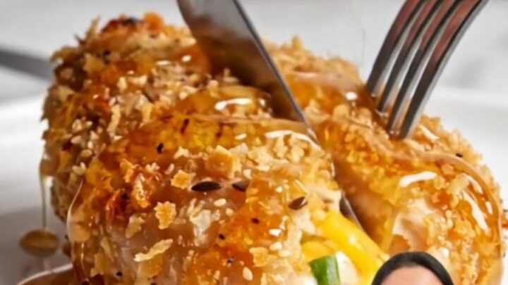 A golden-brown everything bagel crusted chicken breast sliced open to show a creamy cheese center.