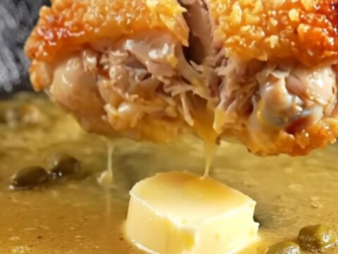 Golden crispy chicken thighs in a lemon butter sauce with fried capers and lemon wheels.