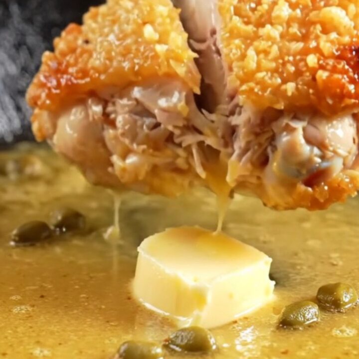 Golden crispy chicken thighs in a lemon butter sauce with fried capers and lemon wheels.