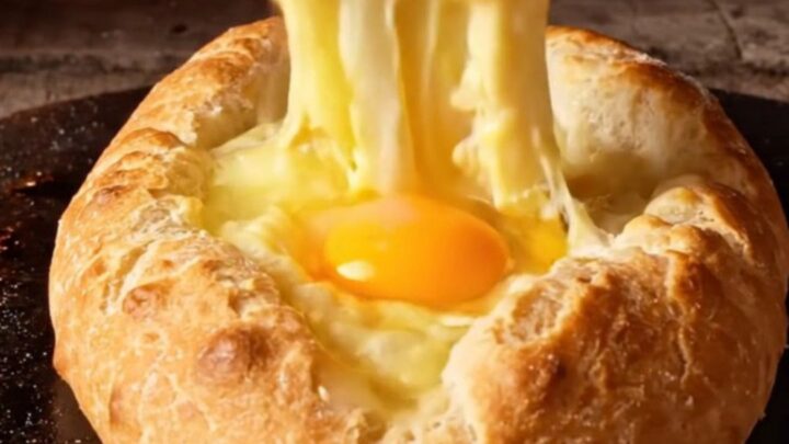 A freshly baked Adjarian Khachapuri cheese boat with a golden crust and molten cheese center.