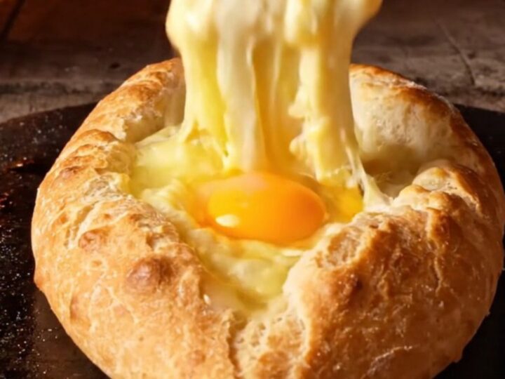 A freshly baked Adjarian Khachapuri cheese boat with a golden crust and molten cheese center.