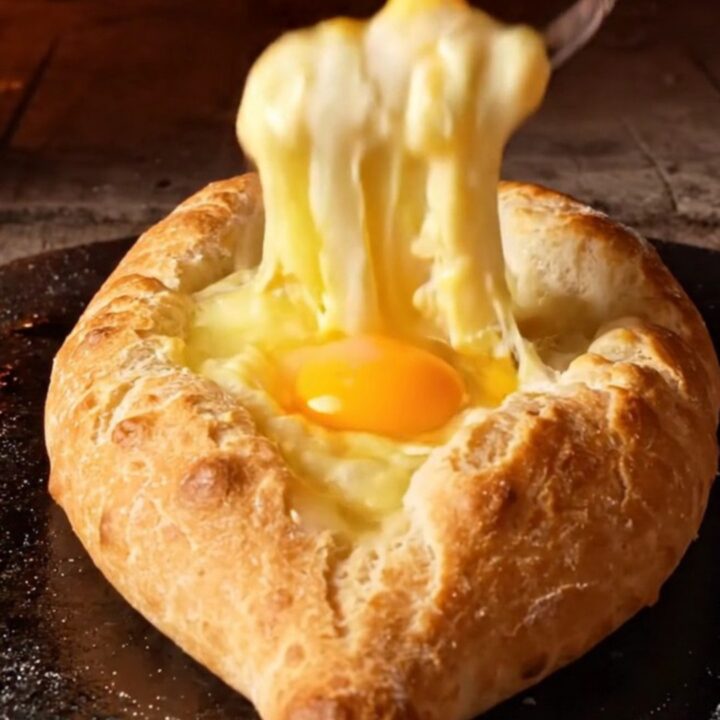 A freshly baked Adjarian Khachapuri cheese boat with a golden crust and molten cheese center.